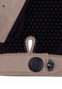 Beiges Kunstleder mit einer strukturierten Oberfläche, einem schwarzen sechseckigen Netzpanel, einem Schlaufen-Detail und schwarzem Knopf-Zubehör.