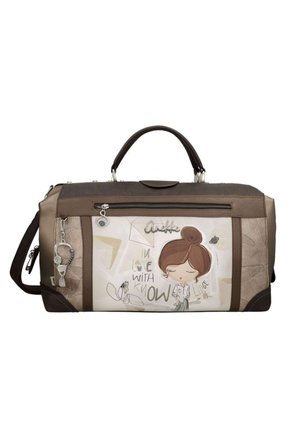 Borsa da viaggio marrone e beige con illustrazione di una bambina dei cartoni animati, tasca frontale con cerniera e tracolla removibile.