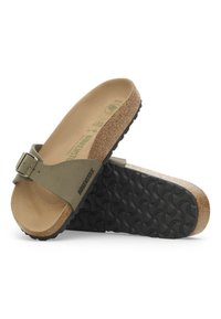 Olivengrøn Birkenstock slidesandal med korkfodbed, sort gummisål og justerbar spændeaccent. Glat tekstur og ergonomisk design.
