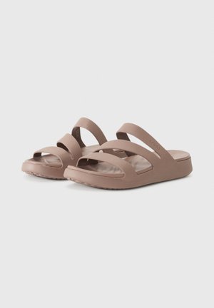 Paire de sandales marron clair à enfiler avec trois larges brides et semelles texturées sur un fond uni.
