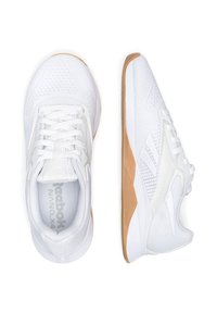 Białe sportowe sneakersy posiadają przewiewną siateczkę u góry, teksturowane wykończenia, płaskie białe sznurowadła oraz gumową podeszwę dla lepszej przyczepności.