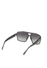 Gafas de sol rectangulares negras con lentes degradados, montura gruesa mate y brazos texturizados; presenta un elemento de diseño angular distintivo en la parte frontal.