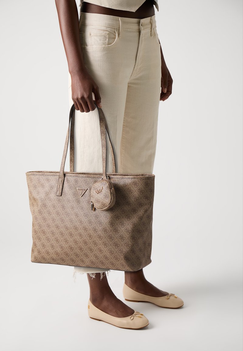 Brown logo-printed tote bag with two handles and a detachable round pouch. Smooth texture, rectangular shape, and subtle gold hardware.