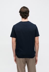 Μπλε ναυτικό βαμβακερό T-shirt με στρογγυλή λαιμόκοψη και κοντά μανίκια. Διαθέτει λεία υφή και απλό σχέδιο χωρίς ορατά μοτίβα.