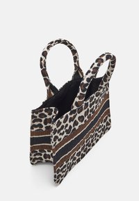 Torebka w wzór leopardzi z podwójnymi uchwytami, teksturowanym materiałem, otwartym wierzchem oraz brązowymi i czarnymi paskami. Wnętrze w kolorze czarnym.