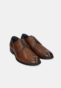 Pantofi de dress din piele maro cu un finisaj neted, bot rotund și sistem de șiret. Au un interior contrastant și o talpă neagră rezistentă.