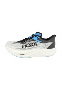 Chaussure de course noire et bleue avec un dessus en mesh léger, une semelle intermédiaire blanche épaisse et une semelle extérieure en caoutchouc texturé. Logo HOKA affiché de manière proéminente.