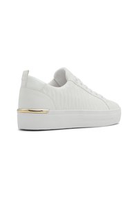 Sneakers bianchi trapuntati con suola piatta e dettaglio dorato sul tallone. Parte superiore in pelle liscia con punta rotonda e chiusura con lacci.