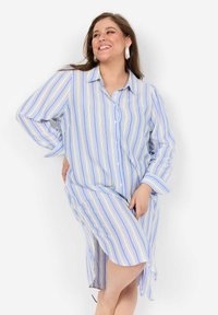 Knoopshirtjurk met blauwe en witte verticale strepen, gemaakt van lichte stof, met lange mouwen en zijsplitten voor bewegingsvrijheid.