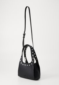 Borsa a tracolla in pelle nera con texture, decorata con borchie argentate lungo il bordo superiore, due manici corti e una lunga tracolla regolabile.