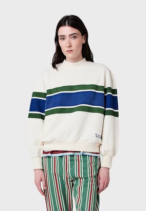 Witte sweatshirt met groene, blauwe en witte strepen over de borst, geribbelde manchetten en een ronde hals. Tekst aan de onderkant: "Niet chemisch reinigen."