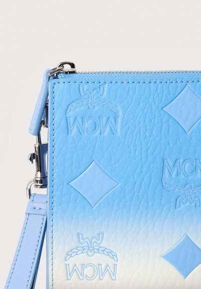 Τσάντα με φερμουάρ σε μπλε και λευκό διαβάθμιση, με ανάγλυφα διαμαντένια σχέδια και λογότυπα «MCM», με αποσπώμενο λουρί και ασημένια εξαρτήματα.