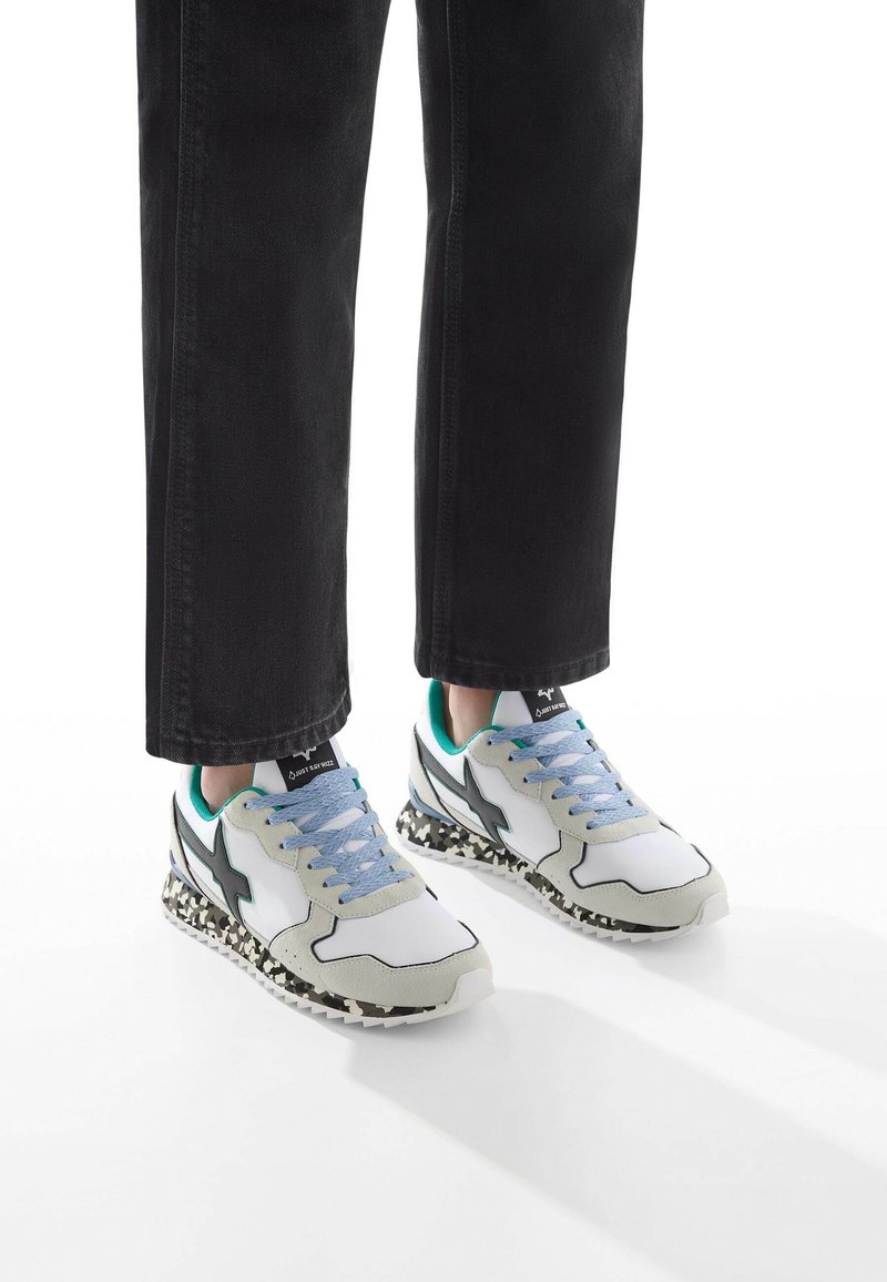 Sneakers con toma bianca, dettagli in suede grigio, lacci blu e suola con motivo in bianco e nero. Design della punta arrotondata.