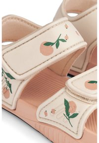 Beige sandaler med persiko- och gröna blommönster, justerbara remmar och texturerade sulor för grepp. Mjukt material med en lätt design.