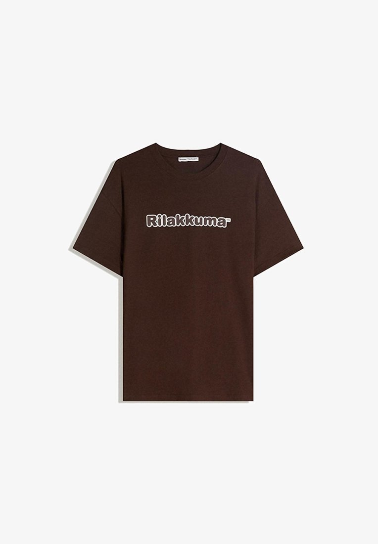 Bruine katoenen t-shirt met een ronde hals en korte mouwen. De weergegeven tekst in het wit luidt "Rilakkuma." Soepele textuur, casual pasvorm.