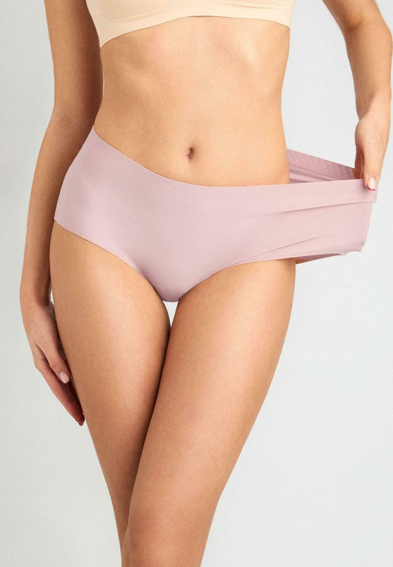 Jasnoróżowa, wysoka bielizna wykonana z gładkiego, elastycznego materiału. Posiada bezszwowe krawędzie dla komfortu oraz minimalistyczny design.