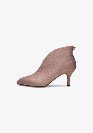 Ruusukultainen nilkkuri, jossa on tekstuurihohtava glitter-pinta, teräväkärkinen muotoilu ja kapea korko. Varustettu takana olevalla nauhalla, joka helpottaa pukemista.