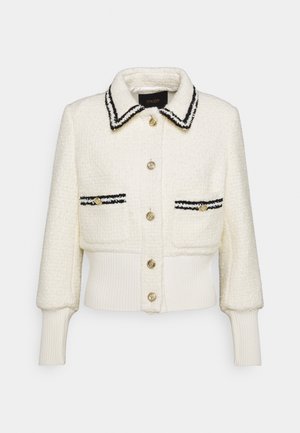 Cardigan blanco con textura, con cuello y solapas de bolsillo con ribete negro, botones dorados, mangas largas y puños y dobladillo acanalados.