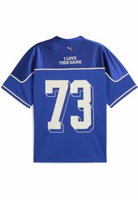 Camiseta deportiva de malla azul con detalles en blanco. Presenta el número "73" impreso en la parte posterior y "ME ENCANTA ESTE JUEGO" encima. Mangas cortas, cuello redondo.