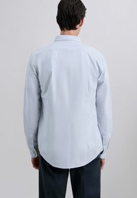 Lichtblauw gestreept overhemd met lange mouwen, een button-down kraag, een gebogen zoom en met knopen. Katoenen mix stof, zachte textuur.