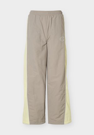 Beige joggingbroek met lichtgele zijpanelen, elastische tailleband en een klein wit Champion-logo op de bovenste linker dij.