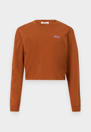 Camisa de manga longa corta em algodão laranja queimado. Apresenta um decote redondo e o logótipo roxo "American Vintage" no peito esquerdo.