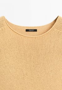 Beige knitted sweater with round neckline and a black label inside collar reading "Massimo Dutti Made in China."