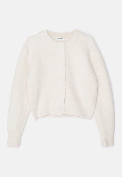 Cardigan bianco lavorato a maglia con scollatura rotonda, maniche lunghe e polsini a coste. Chiusura frontale con cinque bottoni e tessuto morbido e testurizzato.