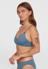 Set di bikini blu composto da un reggiseno triangolare con spalline regolabili e un davanti arricciato, abbinato a uno slip a vita bassa coordinato.
