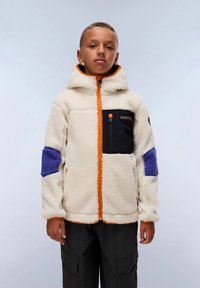 Fleecasta jakna s kapuljačom u krem boji s narančastim patentnim zatvaračem, crnim džepom na prsima i ljubičastim laktovima. Ima teksturiranu, meku površinu.