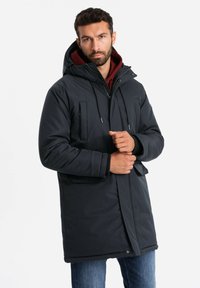 Dunkelblaue isolierte Parka mit Kapuze, Frontreißverschluss und zwei Brusttaschen. Verfügt über verstellbare Kordelzüge und gerippte Bündchen für eine optimale Passform.