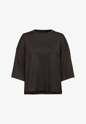 T-shirt noire surdimensionnée en tissu doux, avec un col rond, des épaules tombantes et de subtils détails de couture sur le devant.