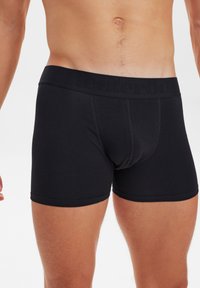 Boxer shorts neri con una morbida cintura elastica che presenta un branding discreto. Realizzati in un tessuto liscio e stretch per garantire comfort.