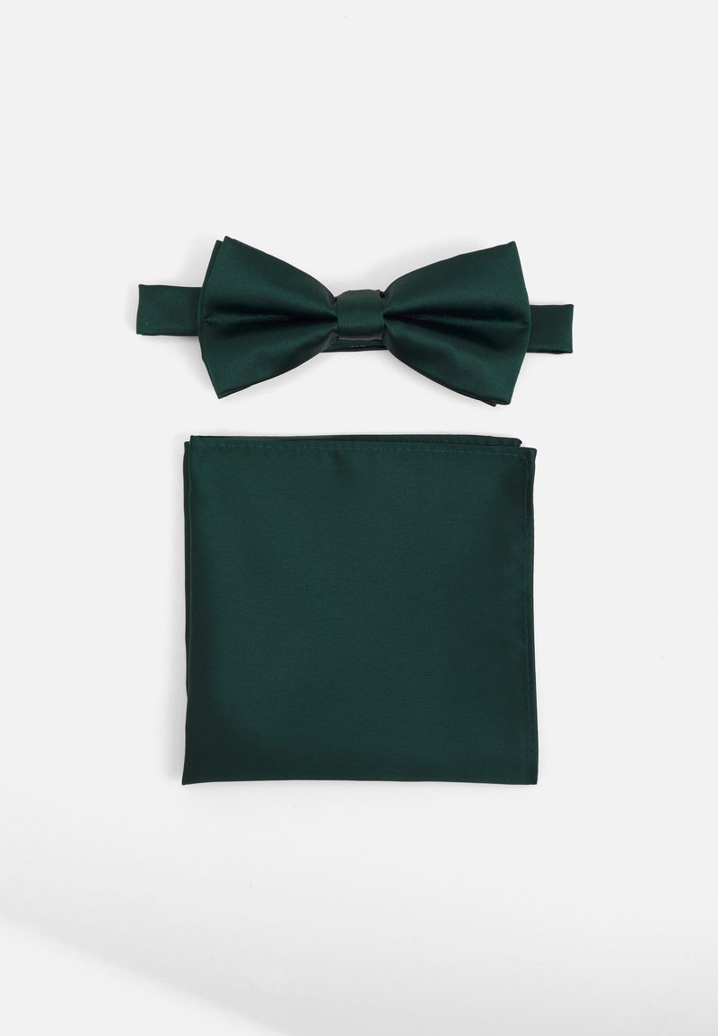 Dark green satin bow tie with matching pocket square. Bow tie features a central knot; pocket square is folded with a clean edge.