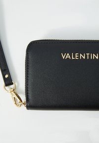 Μαύρο δερμάτινο πορτοφόλι με χρυσά γράμματα "VALENTINO." Διαθέτει κλείσιμο με φερμουάρ και αποσπώμενο λουράκι με χρυσό κλιπ.