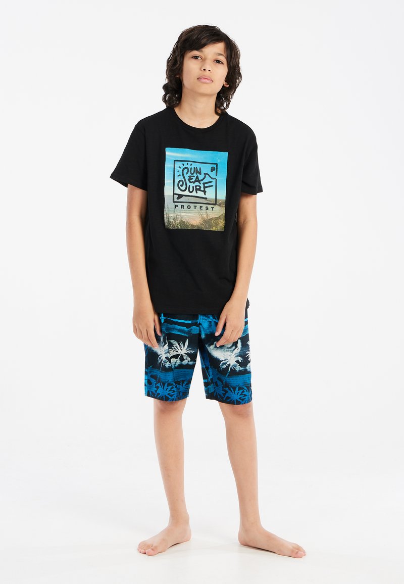 Camiseta de algodón negra con un gráfico de playa, combinada con bañadores cortos azul y negro con un diseño de palmeras.