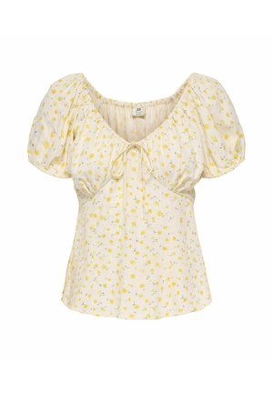 Blouse crème avec manches bouffantes courtes, petit motif floral jaune, encolure en cœur et détail noué à l'avant.