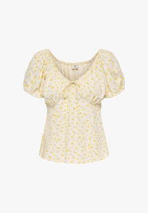 Blouse crème avec manches bouffantes courtes, petit motif floral jaune, encolure en cœur et détail noué à l'avant.