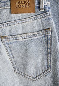 Svijetloplave traperice s jednim stražnjim džepom s karakterističnim šavovima i smešnom kožnom etiketom brenda "JACK & JONES."