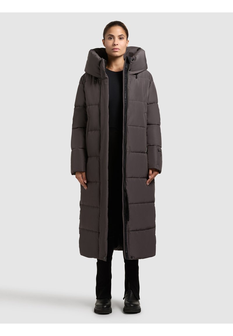 Long, puffy, dark gray coat with a high collar, front zipper, and button accents. Features a quilted design and two side pockets.