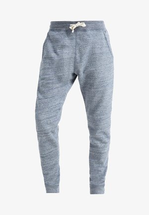 Sivé jogger nohavice s jemnou textúrou a elastickým materiálom, elastickým pásom a nastaviteľnou šnúrkou. Obsahujú bočné vrecká a zúžené nohavice.