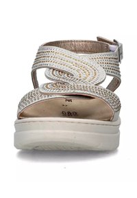 Sandali bianchi con una suola liscia, caratterizzati da borchie decorative in oro e argento su cinghie testurizzate e una fibbia regolabile alla caviglia.