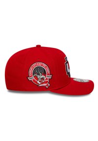 Rød baseballcap lavet af stof, med et broderet logo og detaljer. Capsen har en buet skygge og et justerbart bånd bagpå.