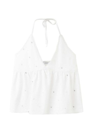 Haut dos nu blanc avec broderie œillet, encolure en V et fermeture à nouer au niveau du cou, présentant une coupe fluide et ample sous la poitrine.
