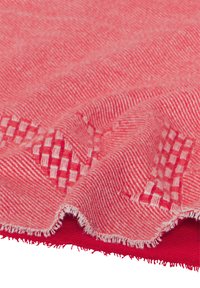 Tekstil tæppe i rosa nuancer med et struktureret mønster; har vævede striber og frynsede kanter. Blødt stof med en glat overflade.