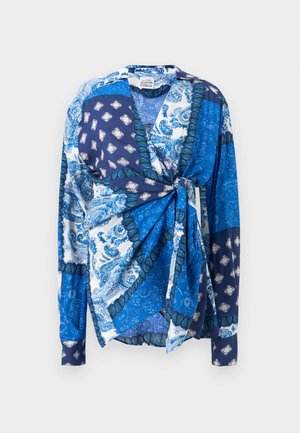 Blå mønstret bluse med lange ærmer, der har et omslagsdesign, kontrasterende paisley- og geometriske mønstre samt et bindedetalje ved taljen.
