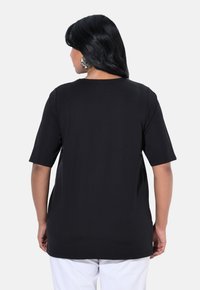 Schwarzes T-Shirt mit kurzen Ärmeln in entspannter Passform, Rundhalsausschnitt, glatter Textur und abgerundetem Saum. Die Rückansicht zeigt keine sichtbaren Muster oder Details.