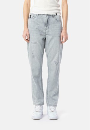 Light blue denim jeans with a loose fit, featuring distressed accents and a straight silhouette. Paired with white sneakers.