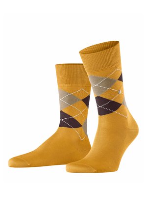 Calze in cotone giallo con un motivo argyle in marrone, grigio e crema, con contorni bianchi, parte superiore a coste e una texture liscia.