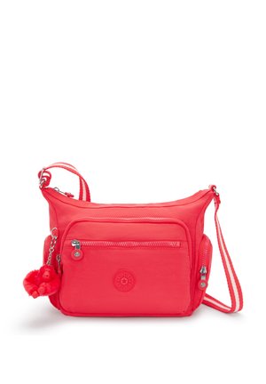 Borsa a tracolla rossa in nylon con cinturino regolabile, tasca frontale con zip e portachiavi decorativo. Presenta una texture liscia e un dettaglio con logo rotondo.